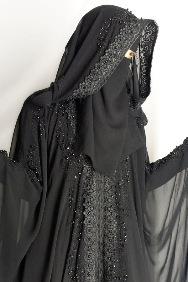 Black chiffon abaya with lace trim and stonework, featuring a hooded design.