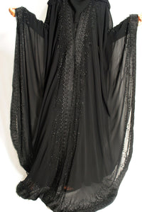 Black chiffon overcoat with hood, lace trim, and stonework embellishments, open sleeves