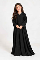 Back view of a girls’ flowing black abaya showing its loose silhouette