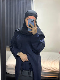 Mirror selfie of person in navy blue nida fabric abaya with black hijab and handbag