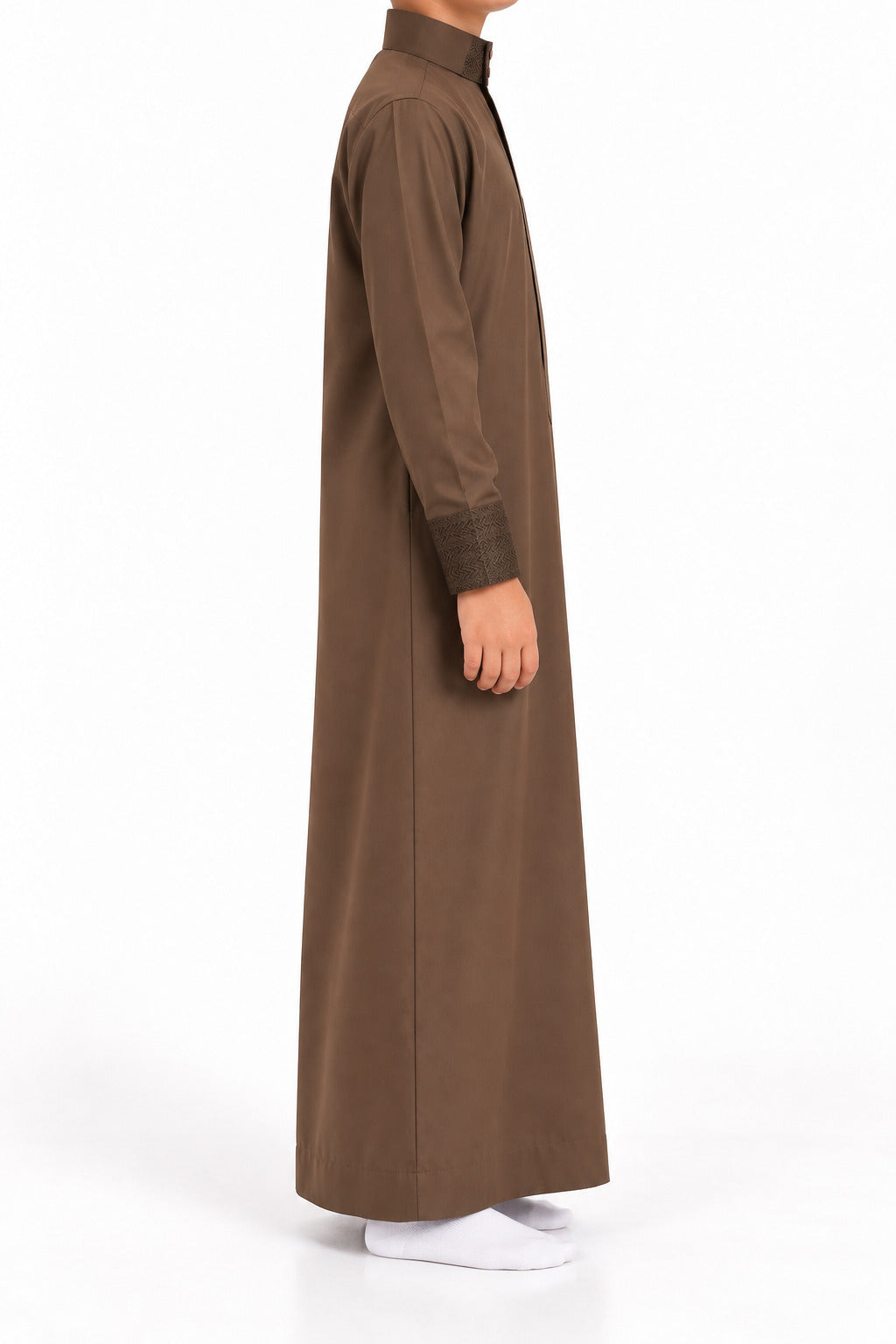 Side view of a boy wearing a brown Saudi thobe with geometric patterned collar and cuffs
