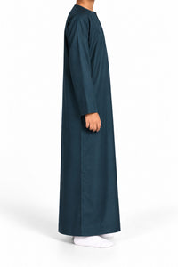 Side view of a boy wearing a dark marine blue Omani thobe
