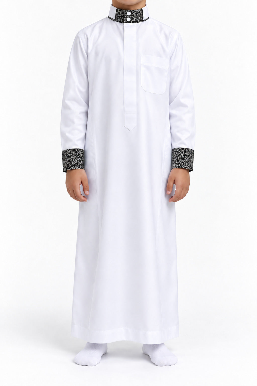 Boy wearing a white Saudi thobe with black and white patterned collar and cuffs, front view