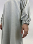 Side view of women’s beige linen closed abaya