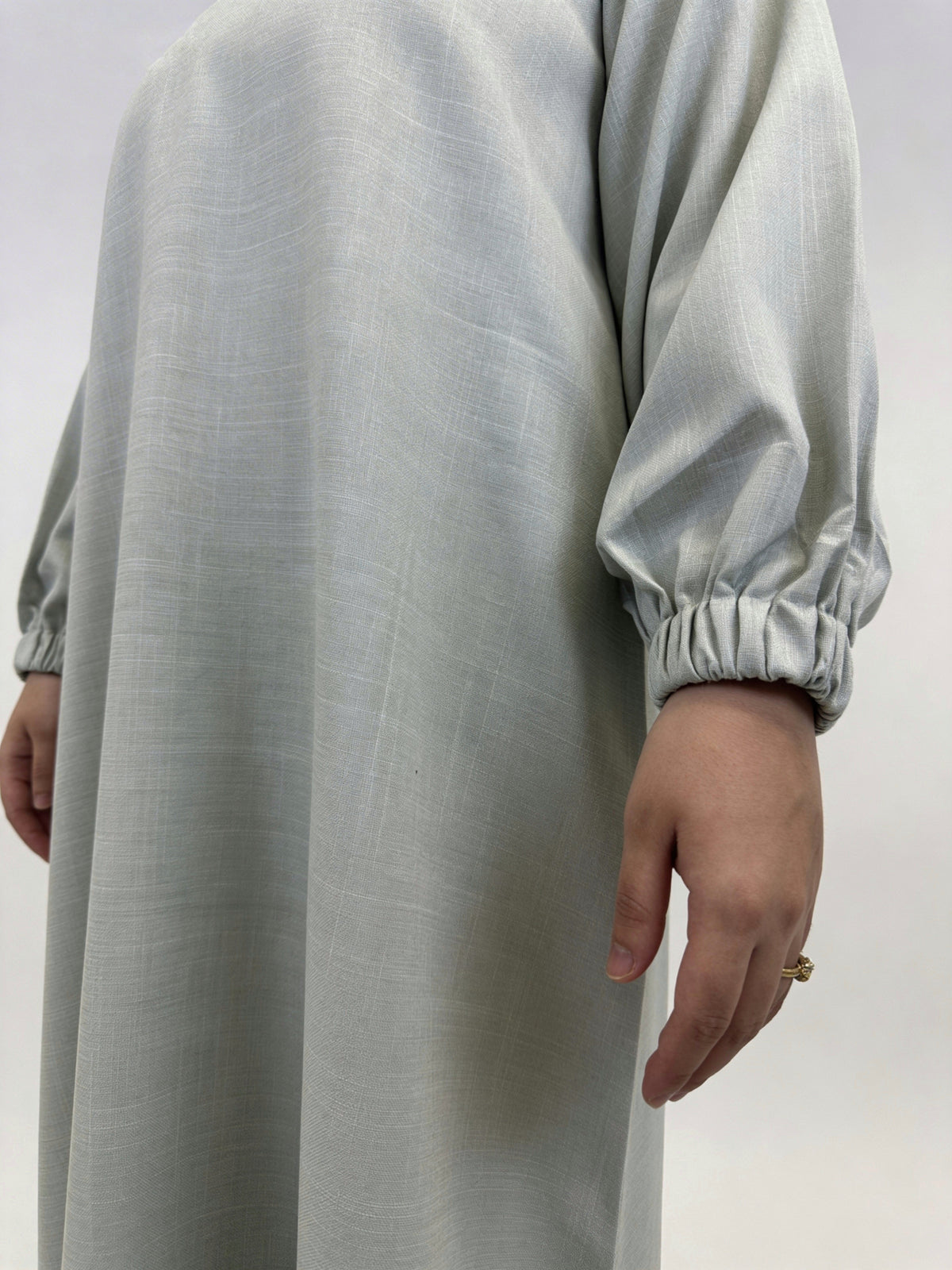 Side view of women’s beige linen closed abaya