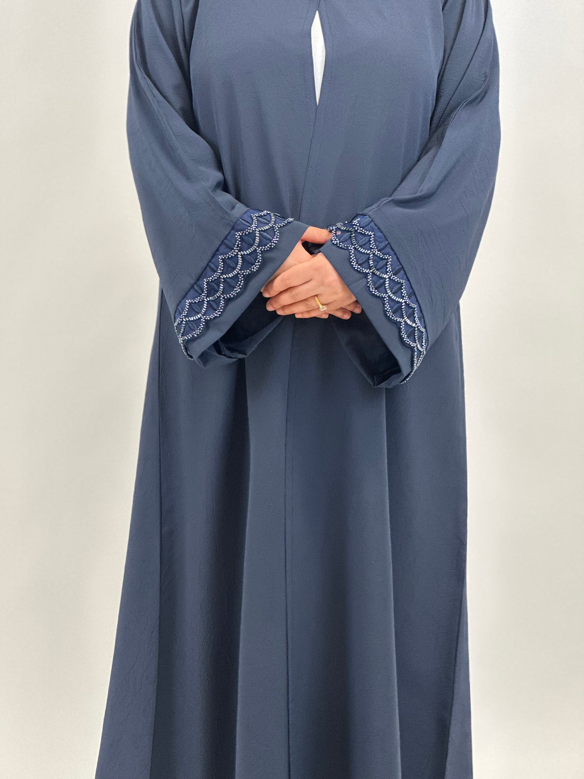 Side view of women’s navy embroidered open abaya